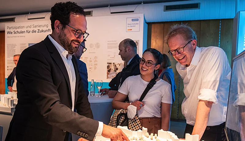 Foto von Jens Wadle im Gespräch mit Besuchern bei der Schulbauausstellung 2022.