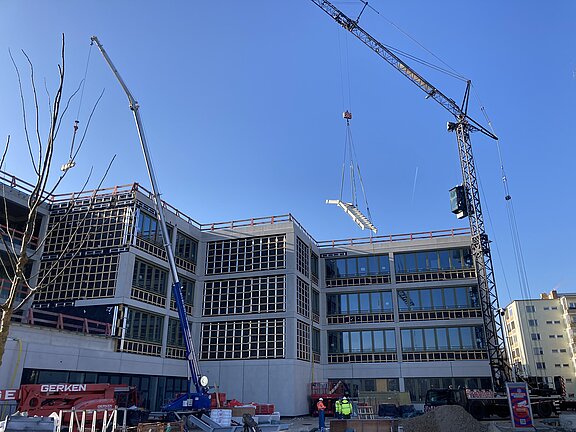 Blick auf die Außenfassade und Baustelle mit Kran