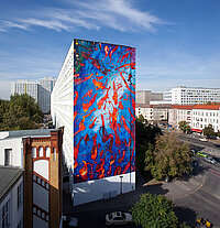 Ein Neubau der HOWOGE mit dem blau-roten Fassadenkunstwerk der LOA