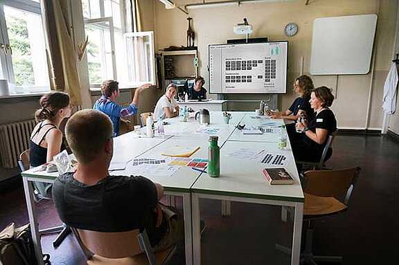 Menschen sitzen an einem großen Tisch