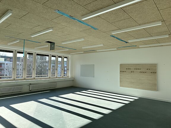 Leeres Klassenzimmer mit Sonnenschein durch Fensterfront