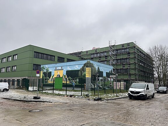 Blick auf die grüne Fassade des Schulgebäudes