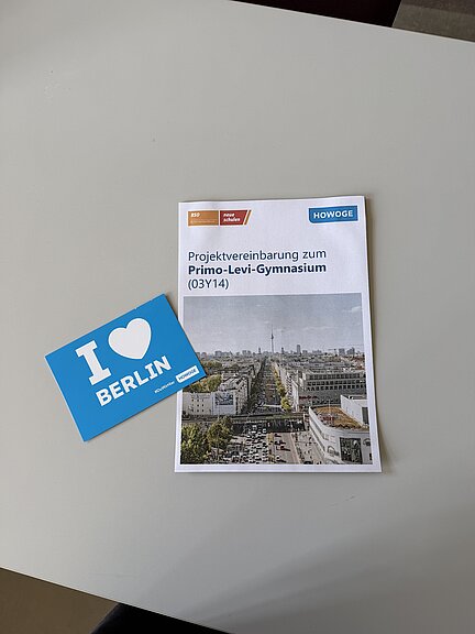 Broschüre Projektvereinbarung zum Gymnasium und I love Berlin Postkarte auf einem Tisch