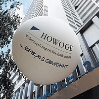 Ein Ballon mit HOWOGE Logo schwebt vor einem Hochhaus