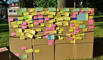 Bild – Eine Wand aus Kartons mit angehefteten Notizzetteln.