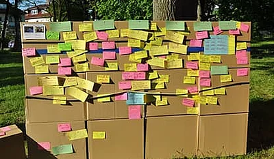 Eine Wand aus Kartons mit angehefteten Notizzetteln.