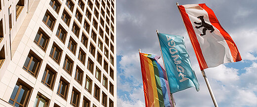 Regenbogenfahne, Howoge-Fahne und Berlin-Fahne wehen vor dem Howoge Hauptsitz