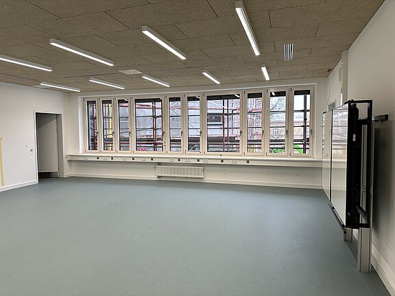 Im Schulgebäude, Klassenzimmer mit Fenstersicht auf Baustelle