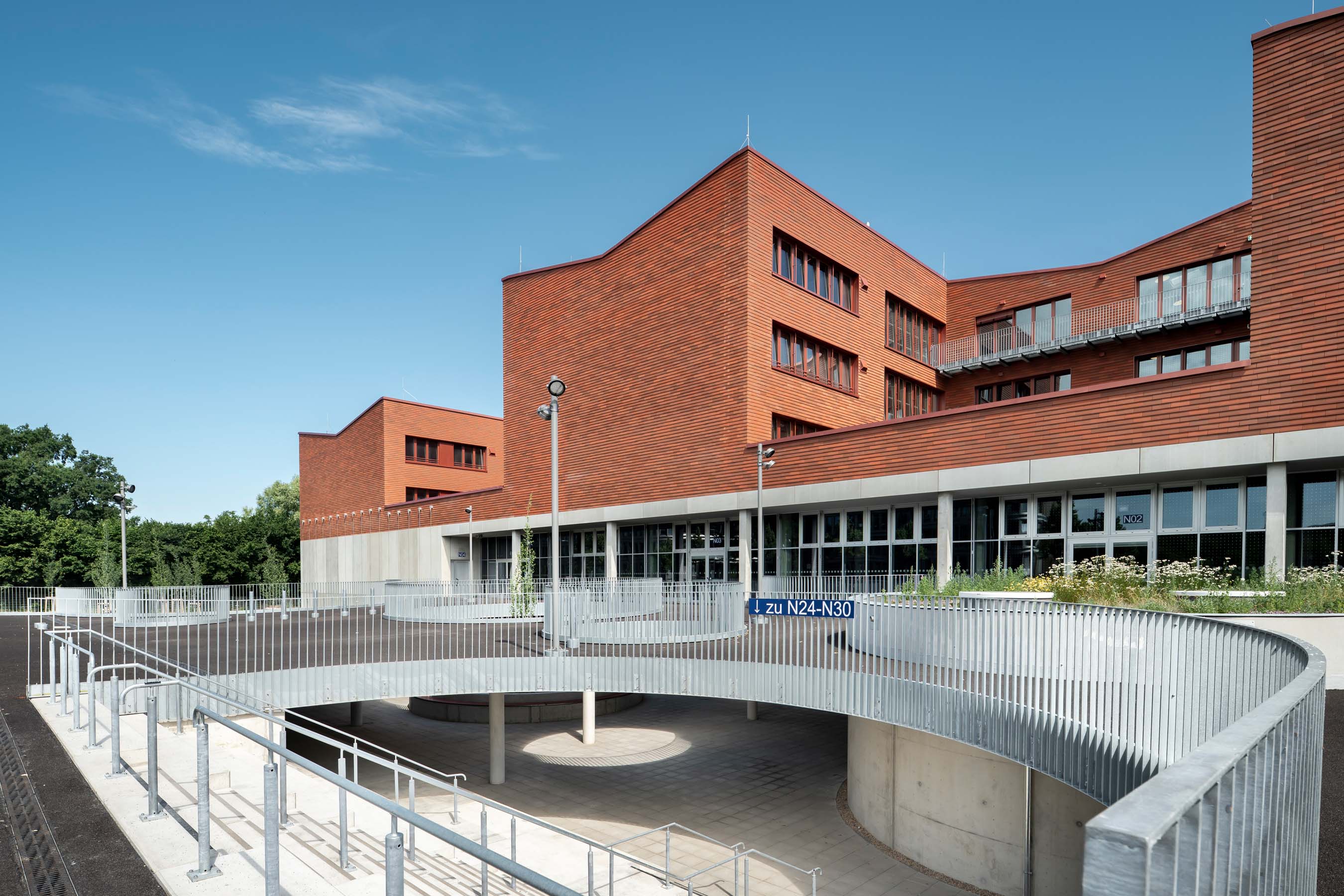 Gebäude mit Holzfassade und Schulhof