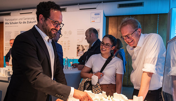 Bild – Foto von Jens Wadle im Gespräch mit Besuchern bei der Schulbauausstellung 2022.