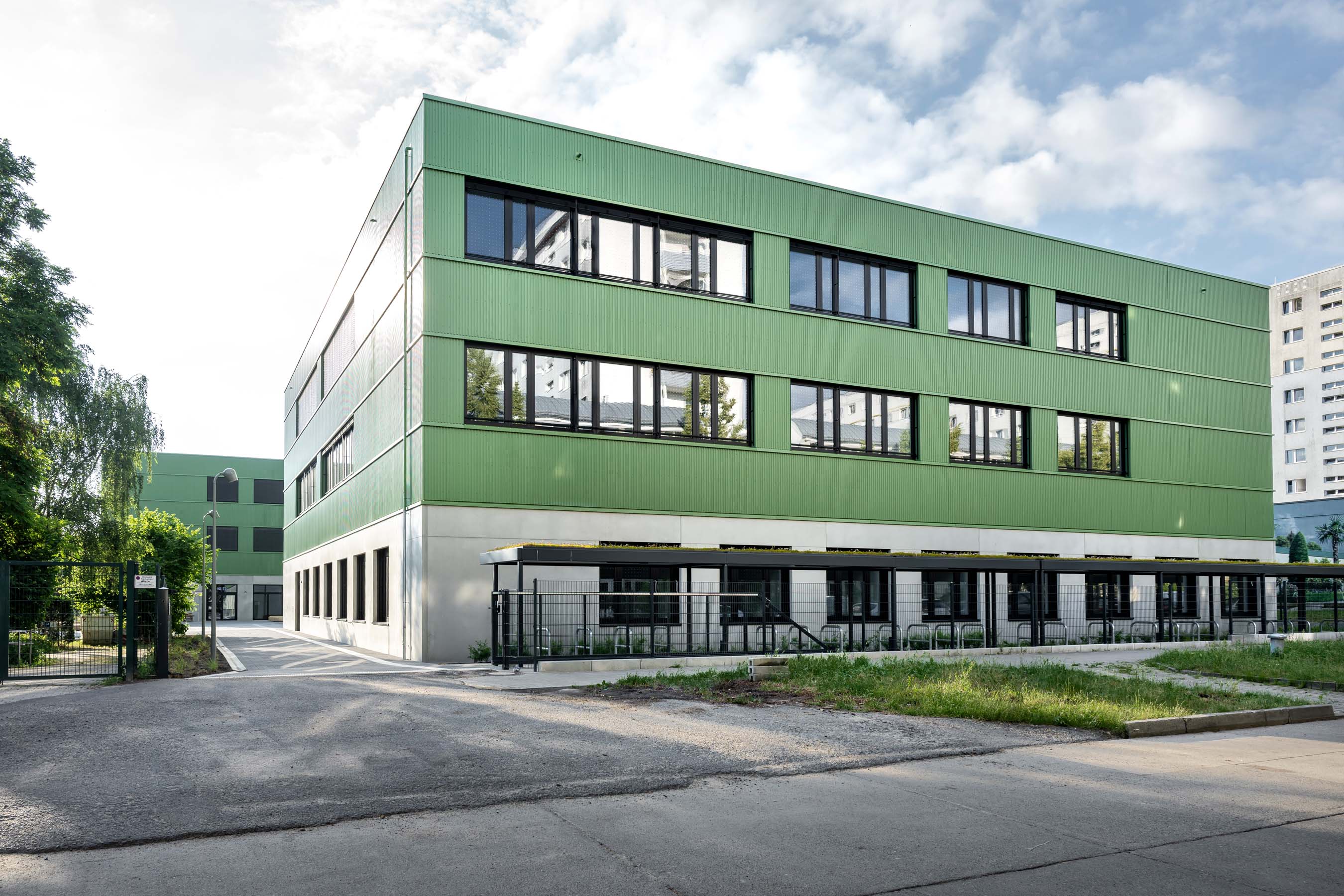 Außenansicht grüne Fassade mit Schulhof