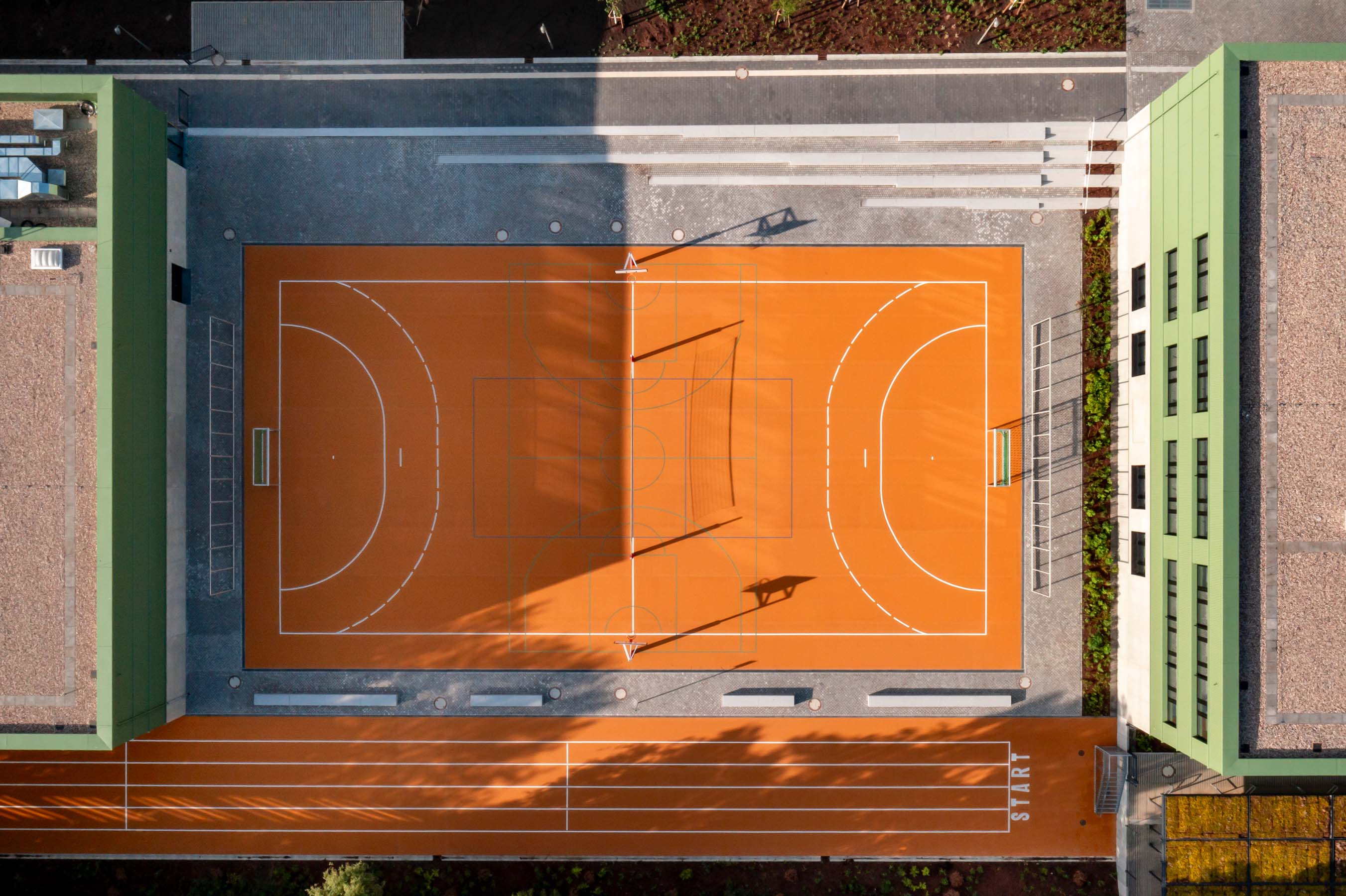 Vogelperspektive auf Basketball, umrandet links und rechts von den Schulgebäuden