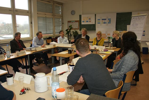 Menschen an einem Tisch beim Stärken-Schwächen-Workshop