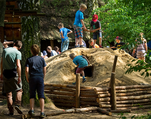 Kinder spielen auf einem Sandhaufen.