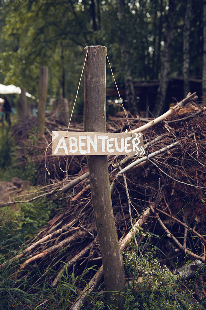 Bild – Ein Stock im Boden, davor ein Schild wo "Abenteuer" drauf steht.