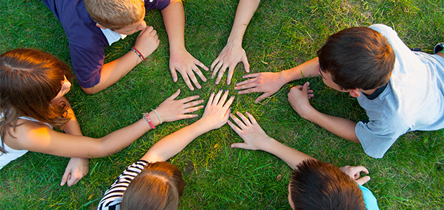 Kinder halten ihre Hände in die Mitte