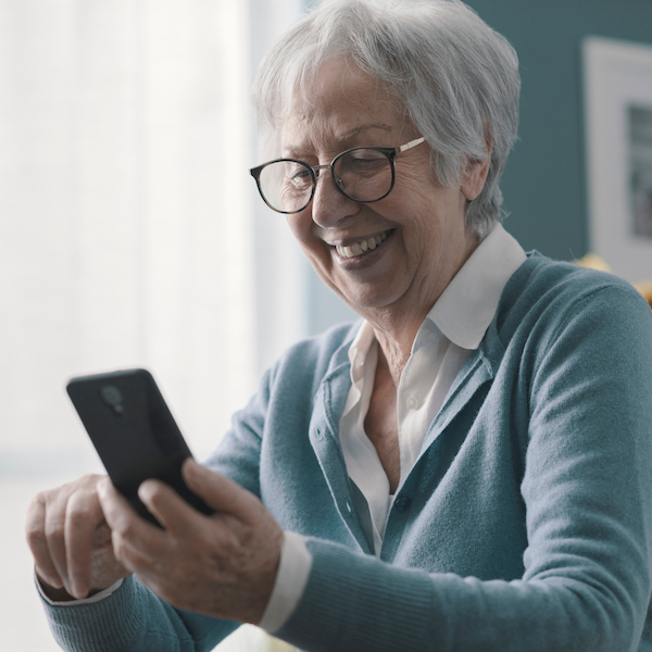 Seniorige Frau mit einem Handy