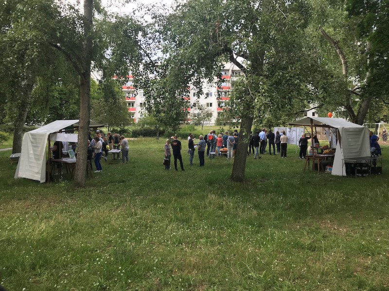 Menschen auf einer Wiese mit Zelten