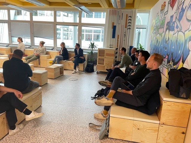 Menschen sitzen in einem Raum und hören zu